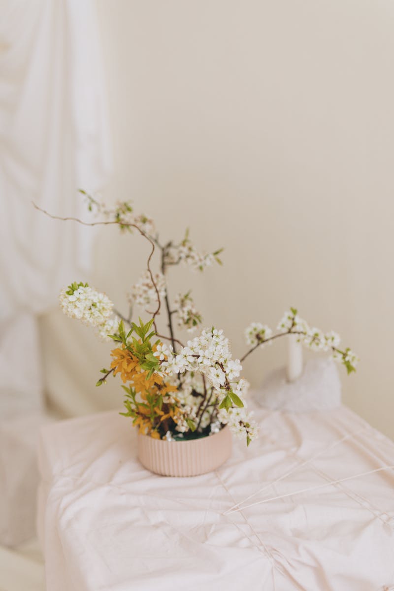 A small vase with flowers on top of a white table